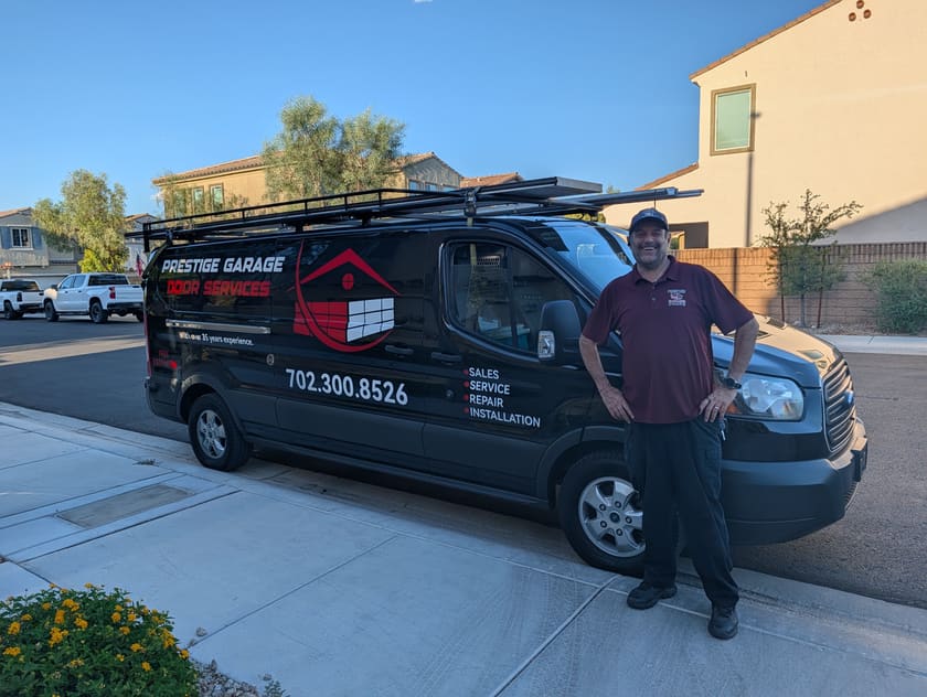 Mario of Prestige Garage Door Services standing beside the company service van in a Las Vegas driveway.