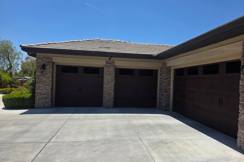 Three woodgrain sectional garage doors installed on a stone and stucco home in the Las Vegas Valley.